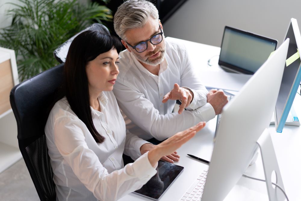 colleagues-collaborating-at-office-desk-with-compu-2025-03-09-04-12-30-utc WordPress Hosting Server Racks